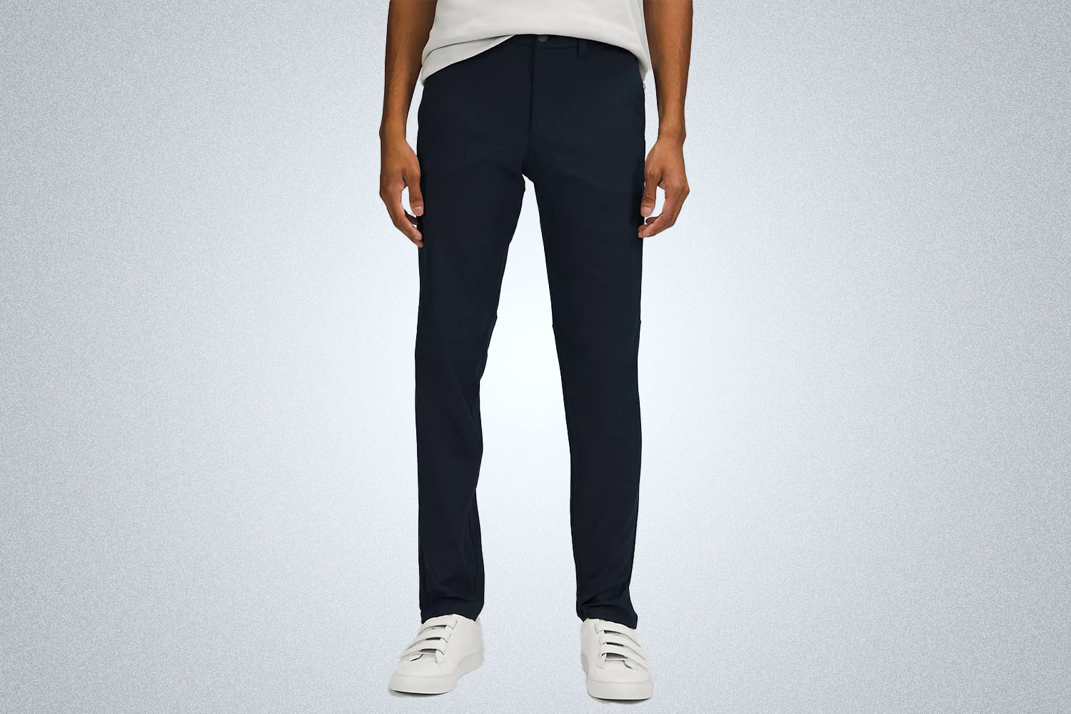 a model in a pair of navy blue pants from Lululemon on a grey background
