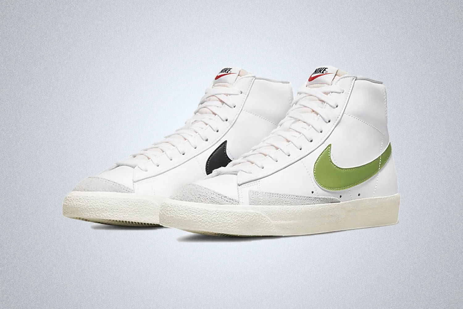 a pair of high-top Nike Blazer Mid Sneakers on a grey background