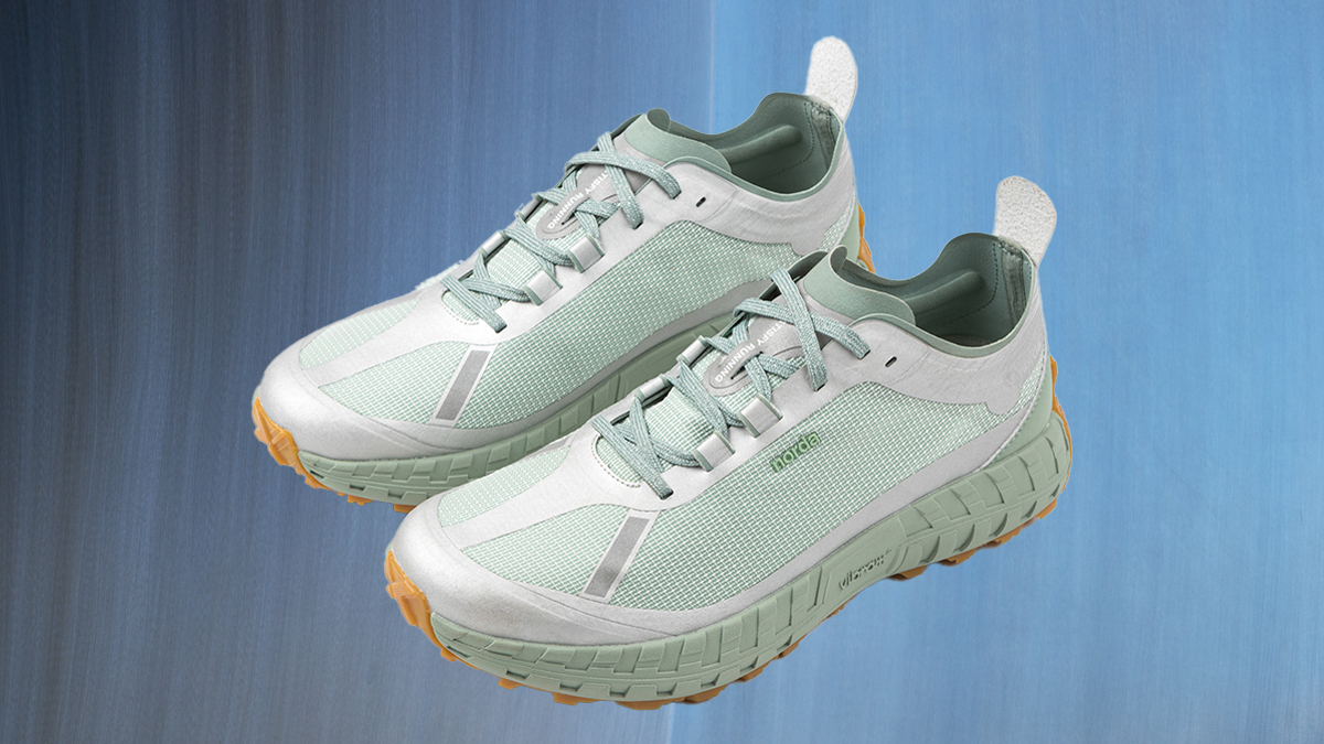 a pair of the Norda x Satisfy Peace and Silence 001 Trail Runner Sneakers on a metallic blue background
