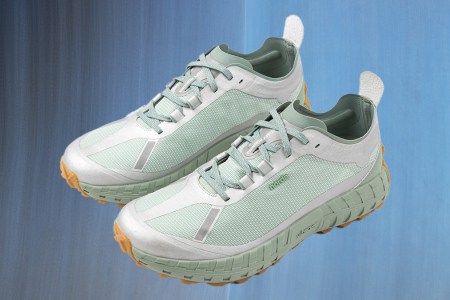 a pair of the Norda x Satisfy Peace and Silence 001 Trail Runner Sneakers on a metallic blue background