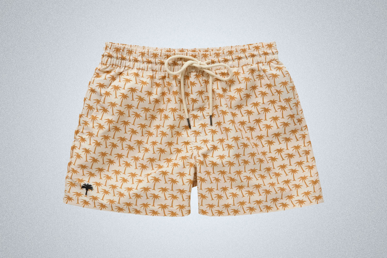 a pair of white swim shorts with palm tree design from OAS on a grey background