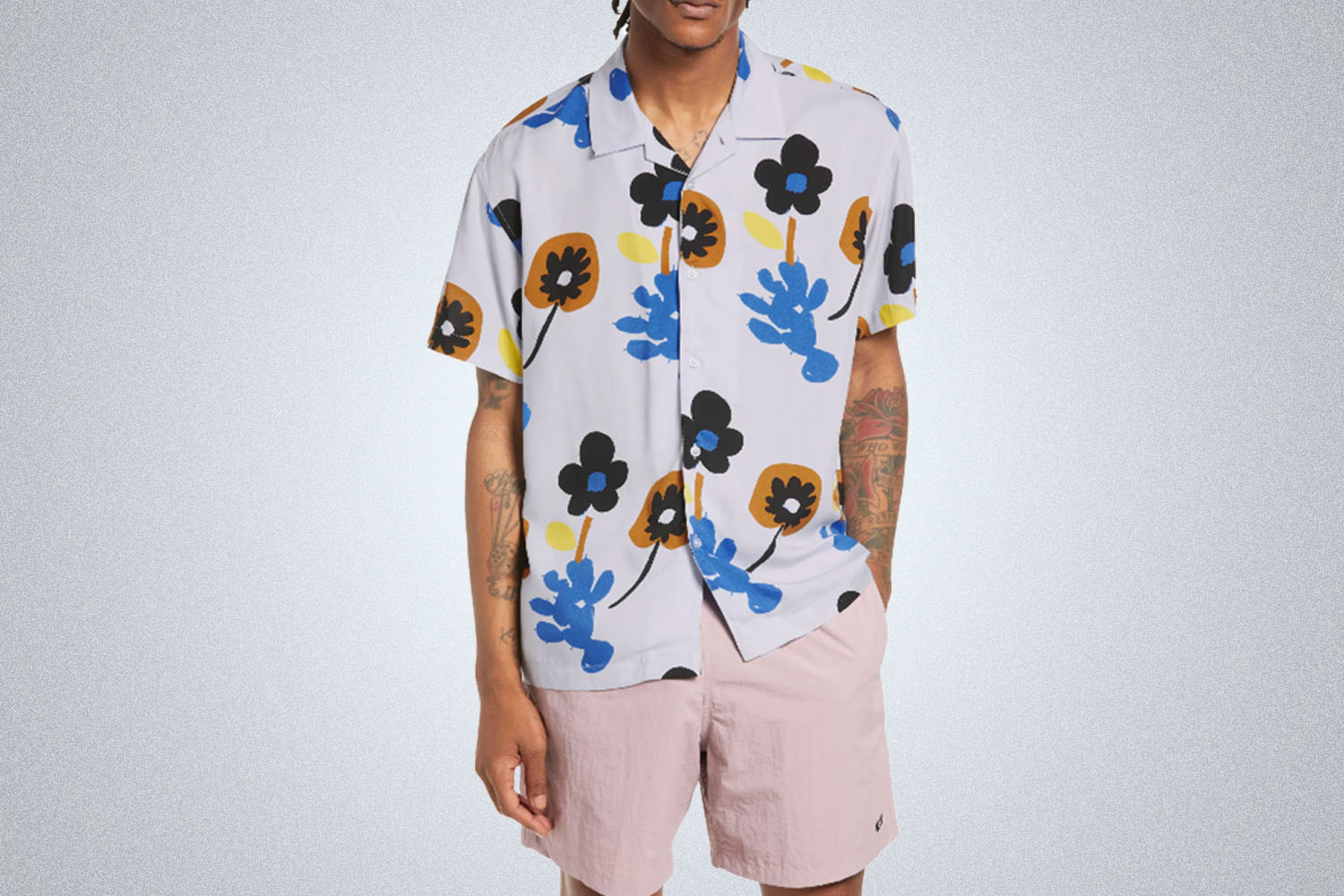 a model in a flower-printed white short-sleeve button down from OBEY on a grey background