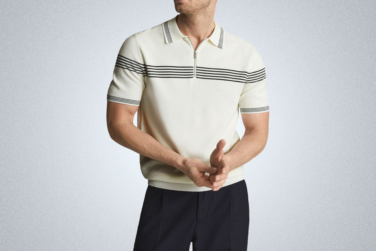 a model in a cream, chest-striped Reiss zip polo on a grey background