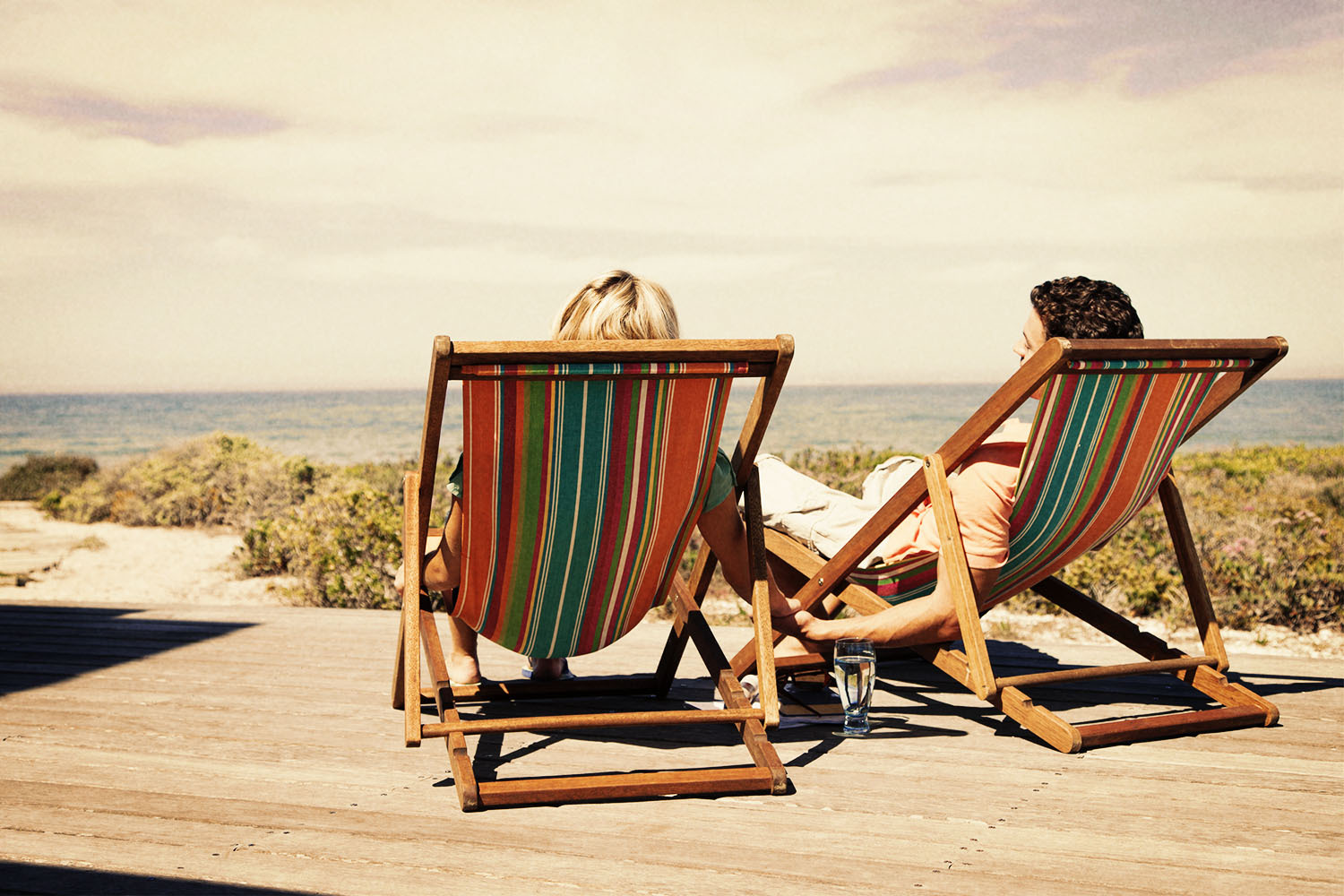 A younger couple in beach chairs overlooking the water
