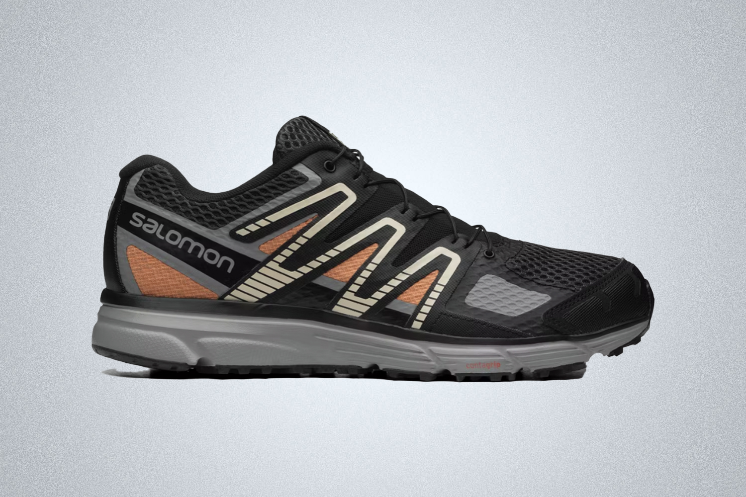 a pair of black sneakers from Salomon on a grey background