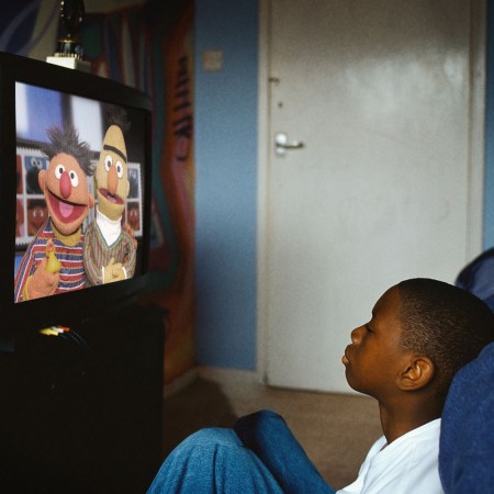 A boy watches Sesame Street on TV
