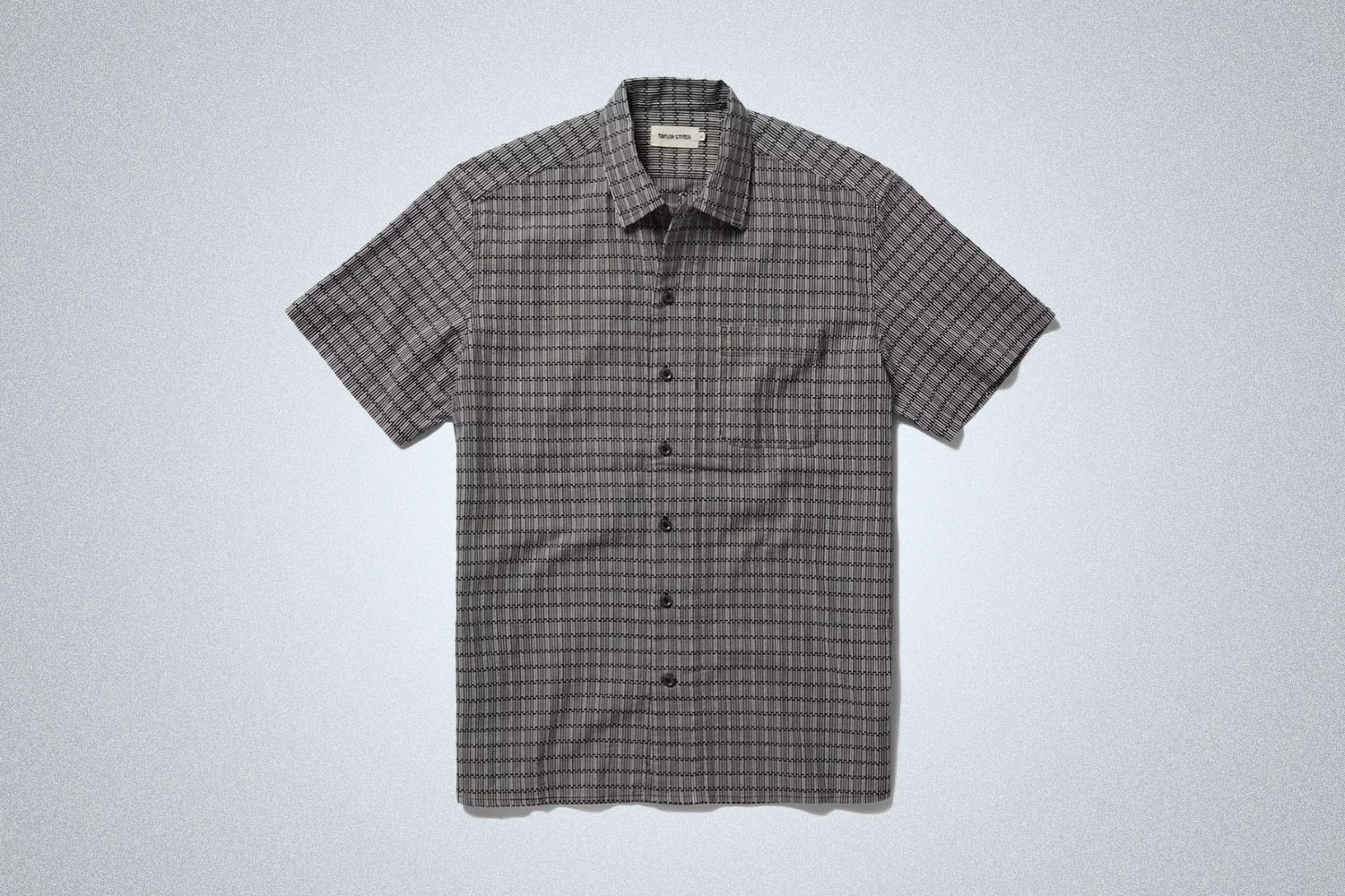 a grey and black checked short sleeve button up from Taylor Stitch on a grey background