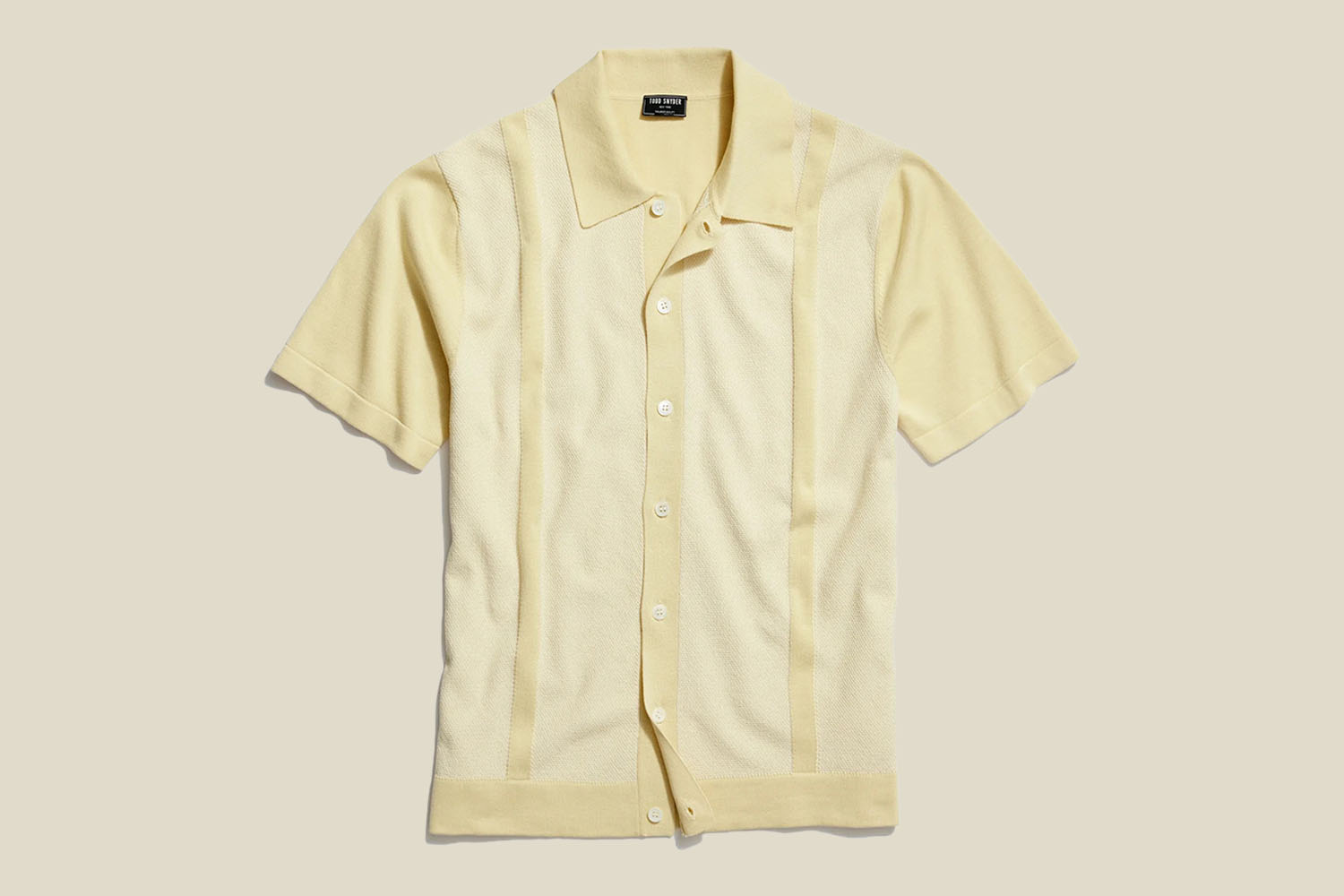 a yellow-striped sweater polo from Todd Snyder on a yellow background