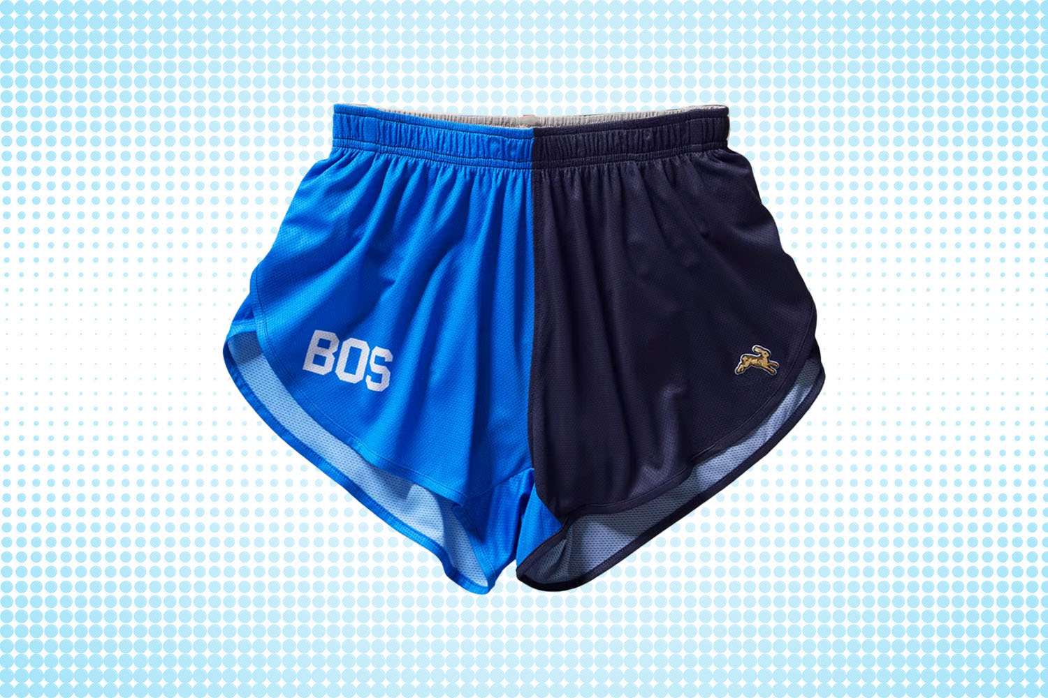 a pair of two-toned black-and-blue split shorts  from Tracksmith on a white and blue dotted background 
