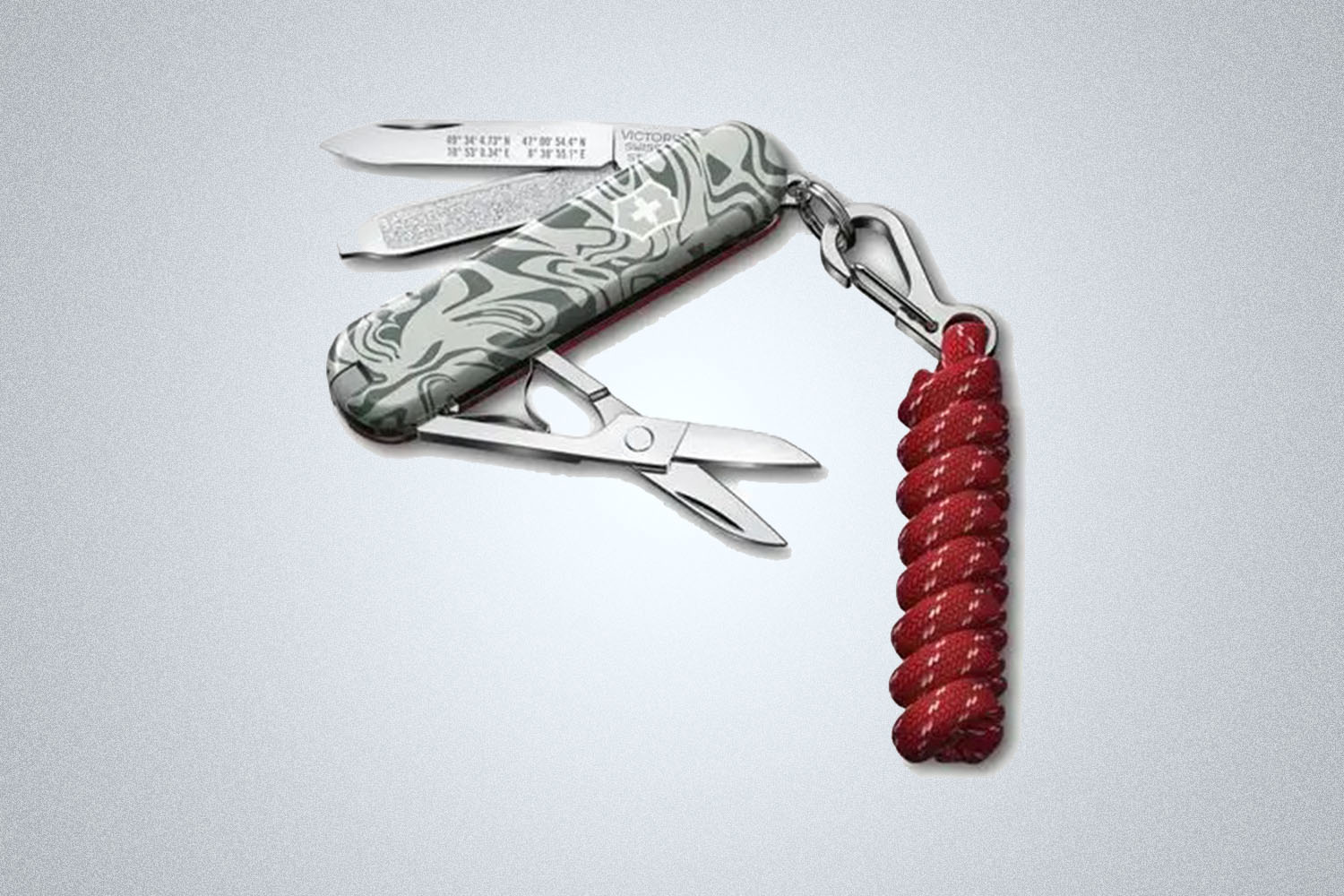 a red and silver-camo multitool from Victorianox on a grey background