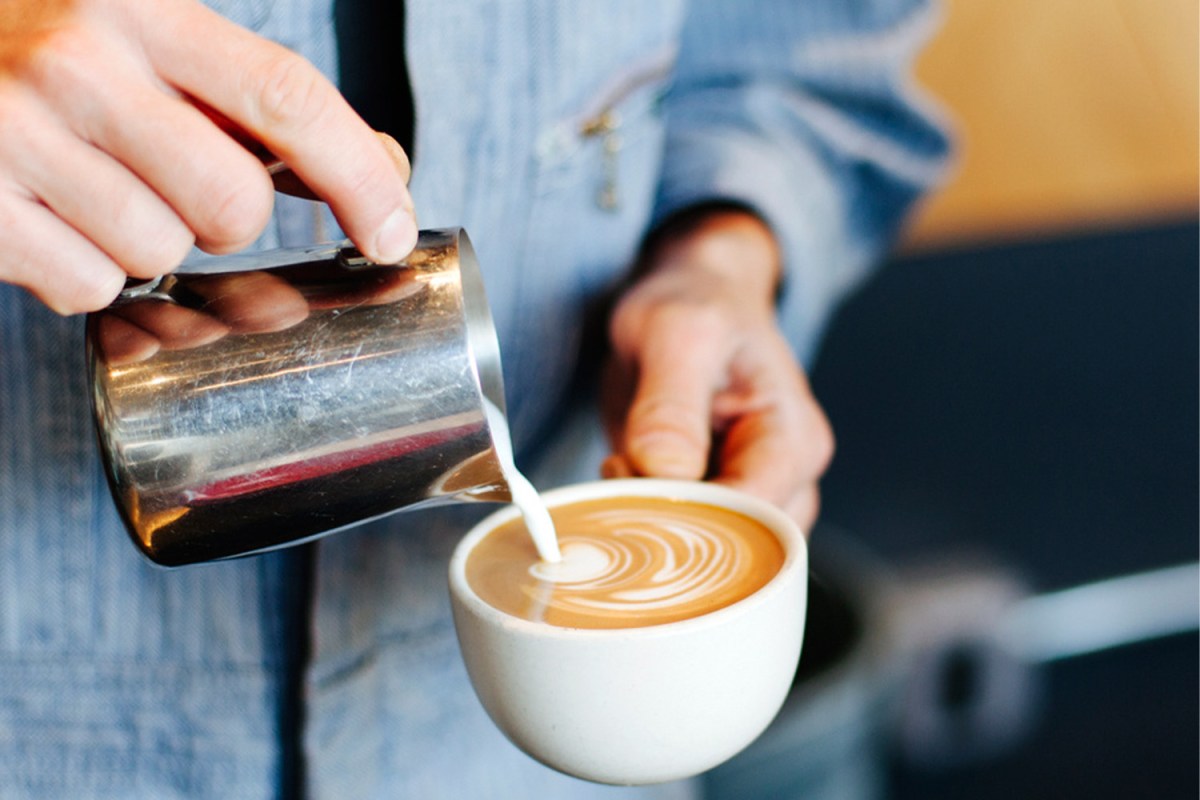 A barista pouring milk into a latte at Linea Caffe in San Francisco, California