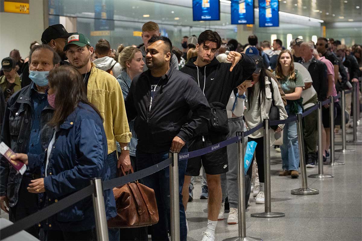 Travellers wait in a long queue to pass through the security check at Heathrow on June 1, 2022 in London, England.