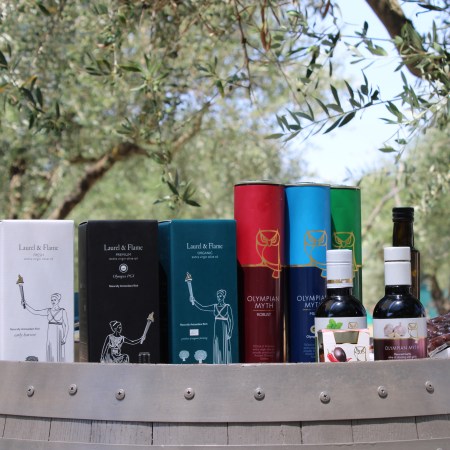 A row of olive oils resting on a barrel.