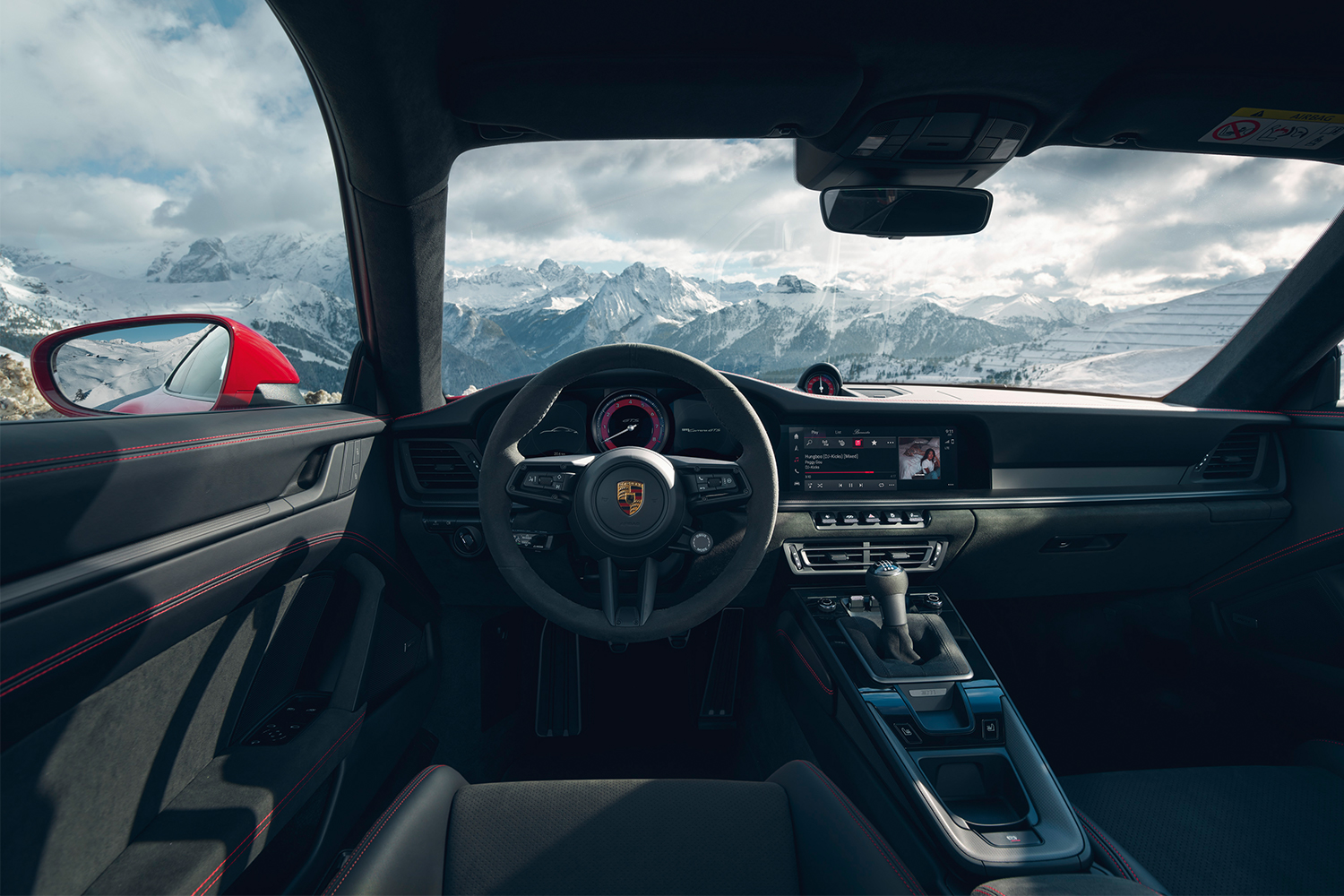 The interior of a 2022 Porsche 911 Carrera GTS with mountains in the background