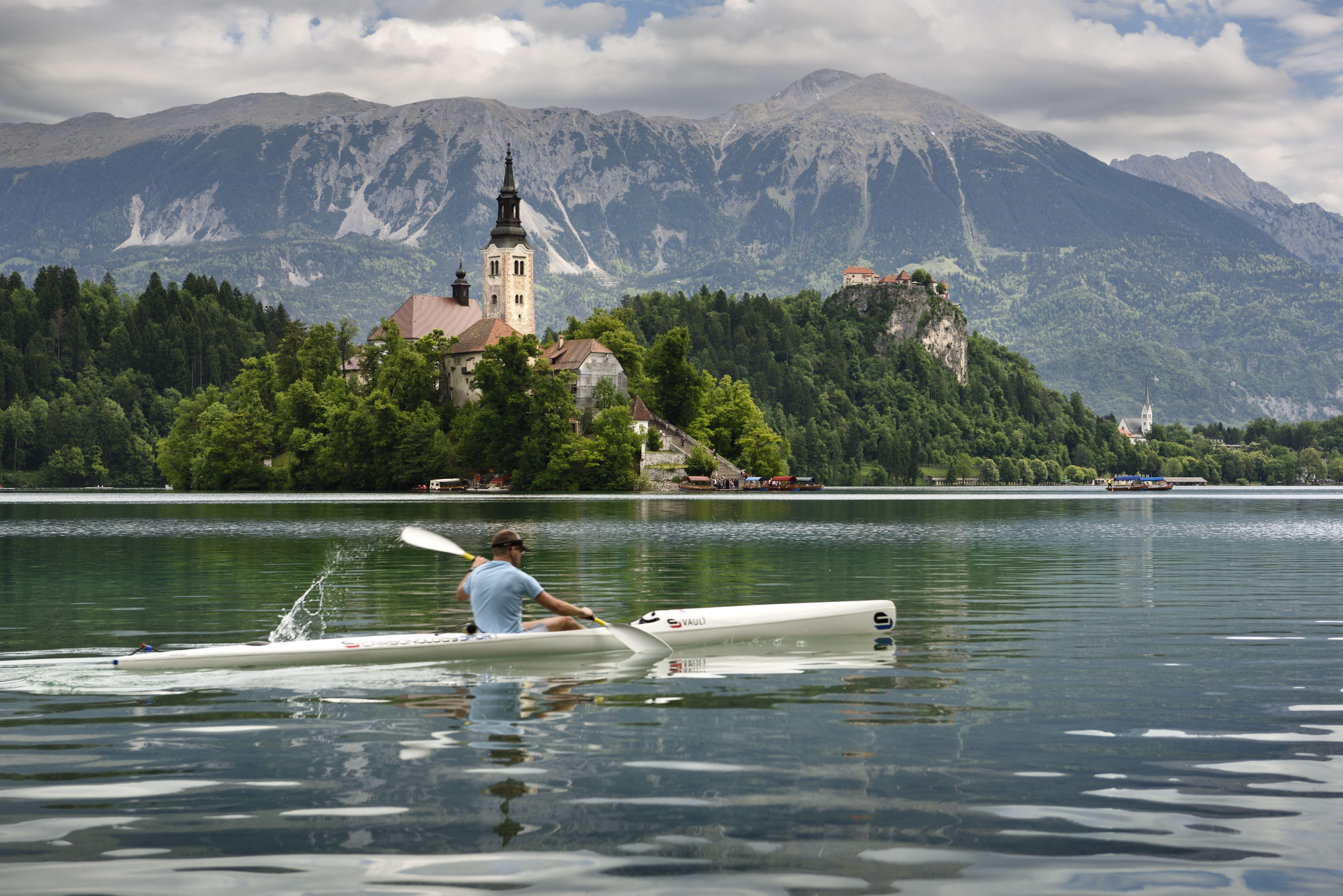 A kayaker on Slovenia's Lake Bled with a castle in the background.