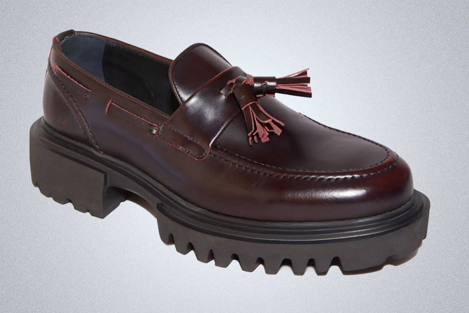a pair of brown leather lug sole loafers from All Saints on a grey background