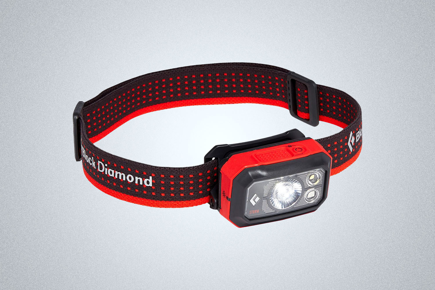 a red and balck headlamp from black diamond on a grey background