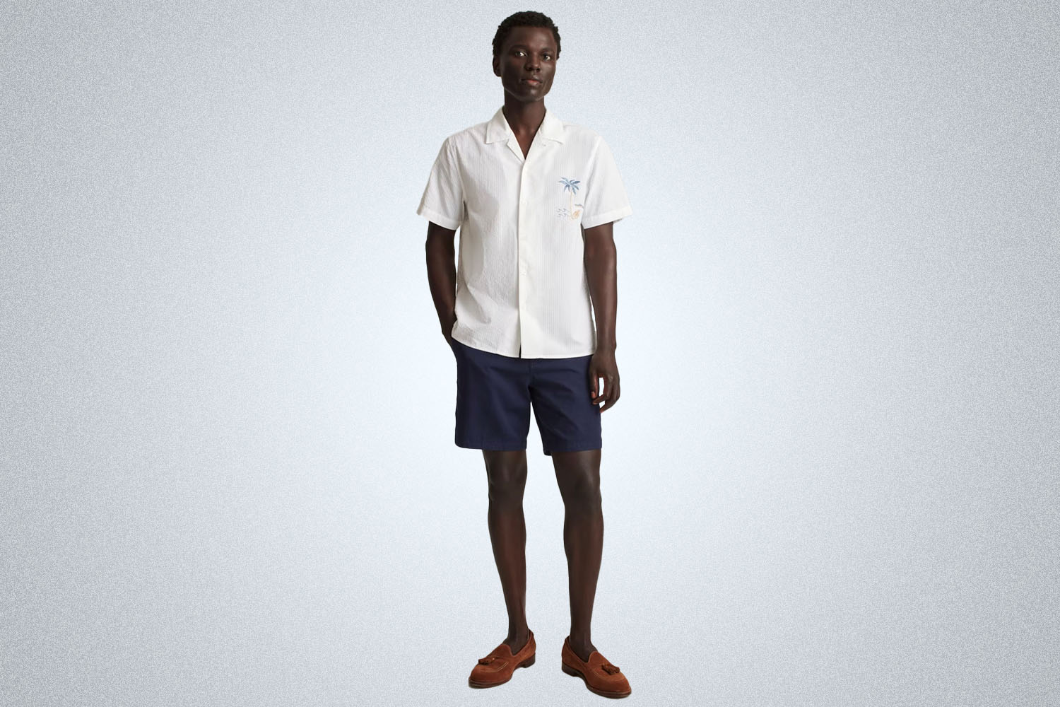 a model wearing an all white riviera shirt from Bonobos on a grey background