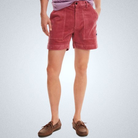 a model in a pair of red corduroy shorts from Brooks Brothers on a grey background