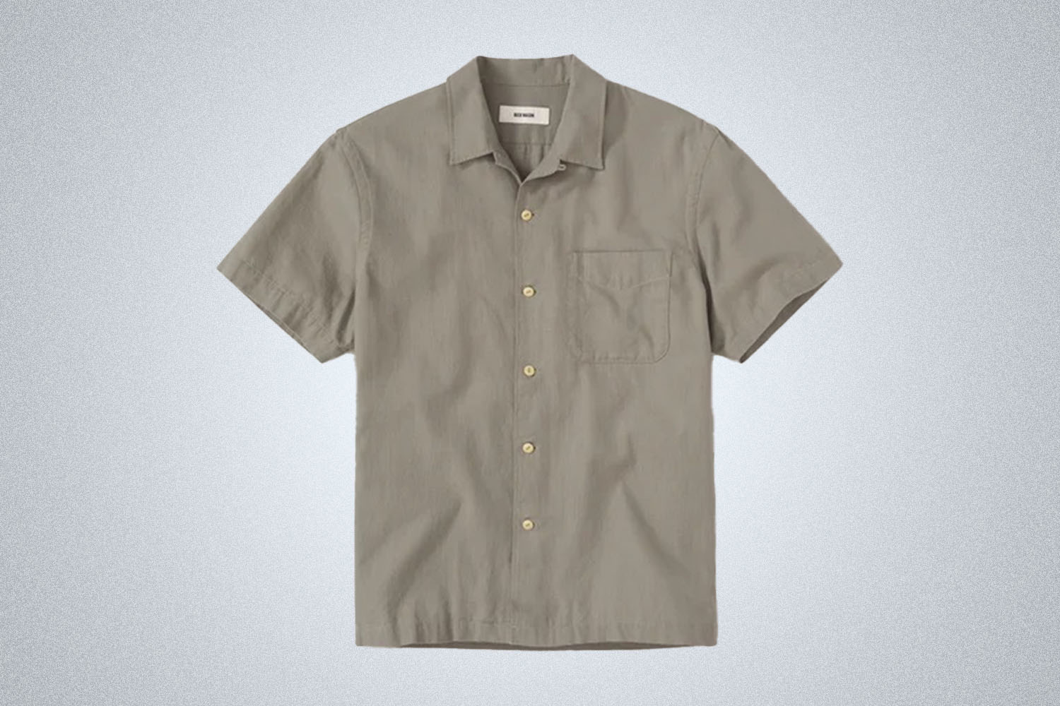 a green camp shirt from Buck Mason on a grey background