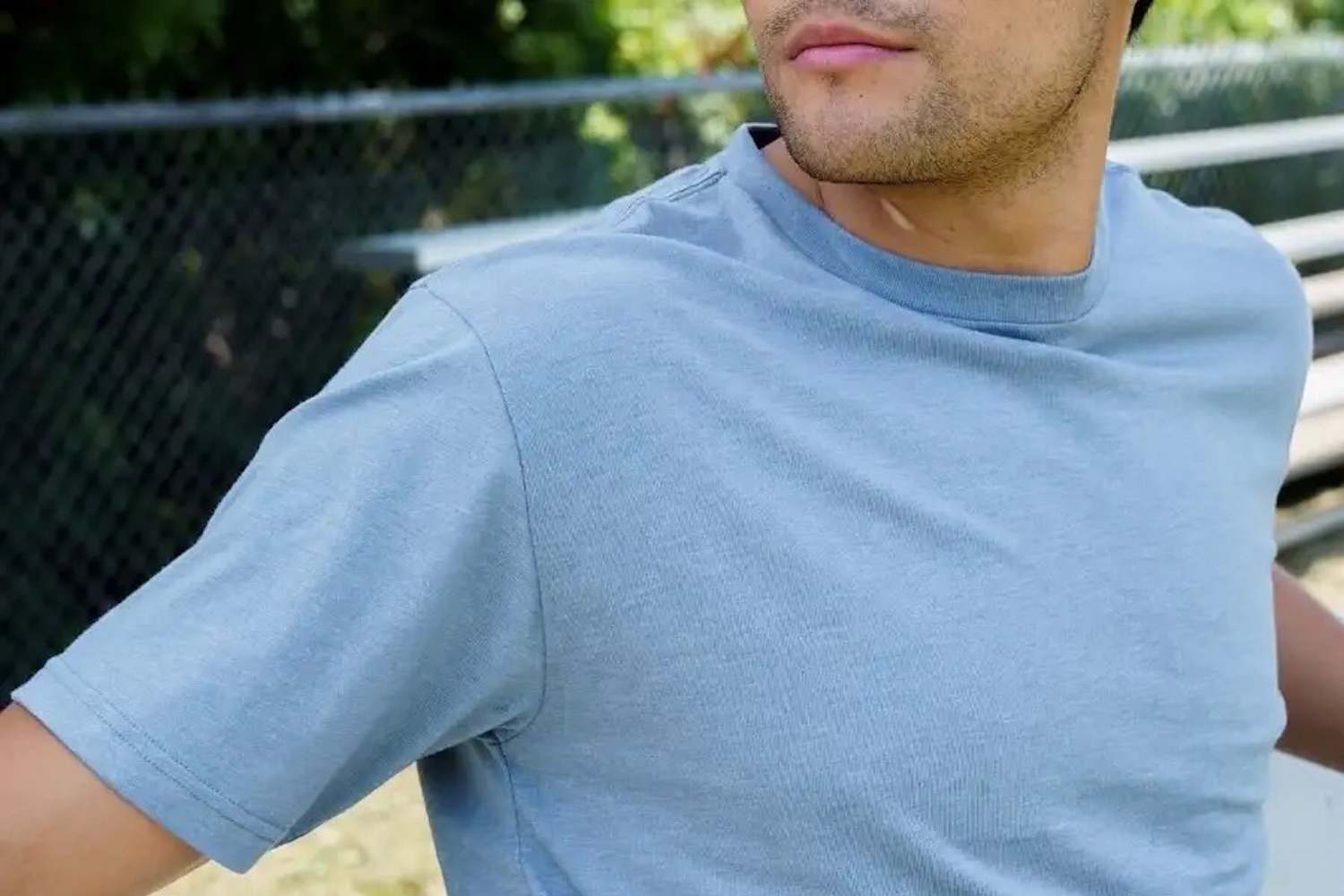 a model in a light blue Fresh Clean Threads shirt outside