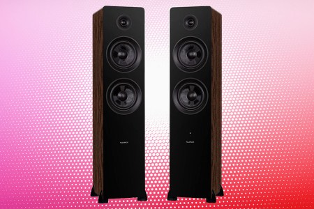 A pair of black and walnut ai81 standing tower speakers from Fluance on a multi-colored red and pink dot background