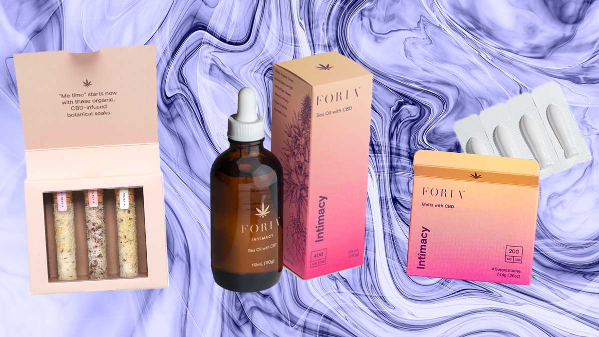 Foria's bath salt trio, CBD Sex Oil and CBD suppositories on a wavy purple background.