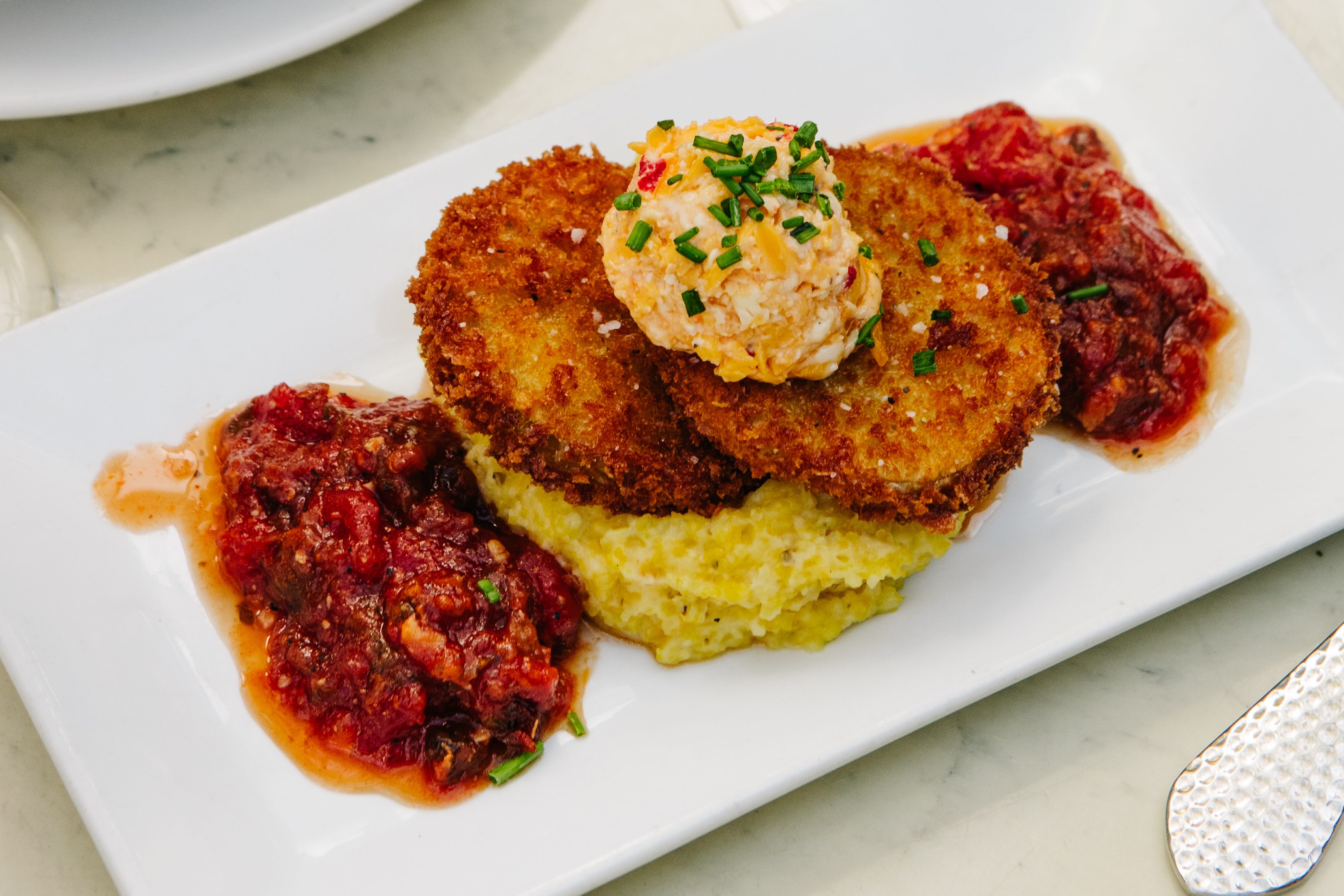 Fried green tomatoes with pimento cheese, grits and tomato bacon jam.
