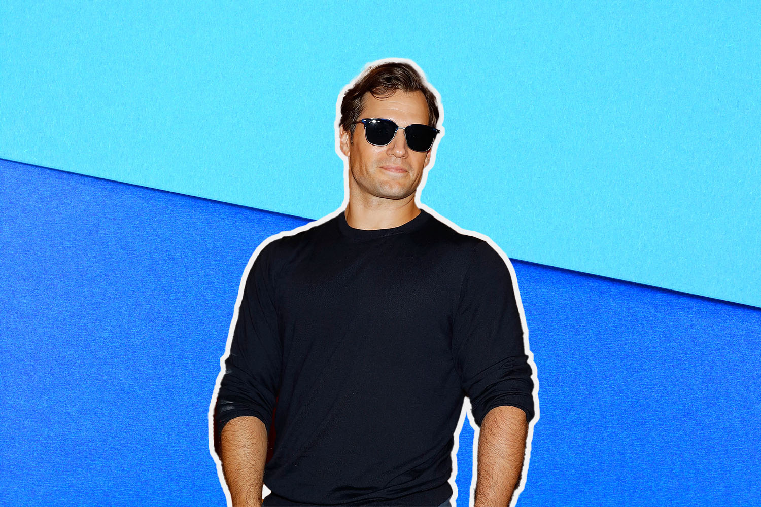 A photo of Henry Caville wearing sunglasses against a two-toned blue background