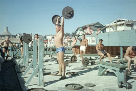 A group of men lifting at Muscle Beach in the 1960s.