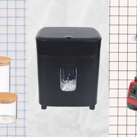 Glass jars, a paper shredder and a Vitamix blender on a paper background.