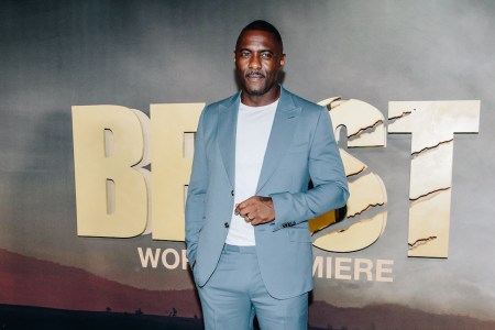 A photograph of actor Idris Elba at the Premier of "Beast" in a light chambray bule suit and white tee shirt