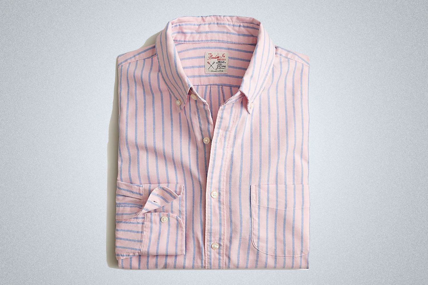 a pink and blue striped broken-in oxford shirt from J.Crew on a grey background