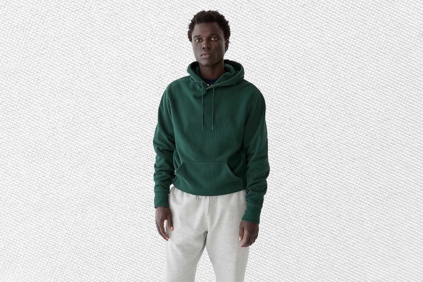 a model in a green hoodie from J.Crew on a grey background