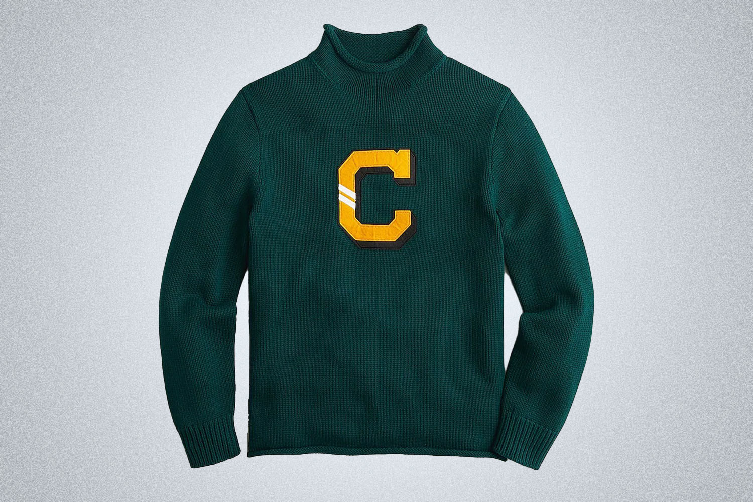a green letter-embroidered rollneck sweater from J.Crew on a grey background