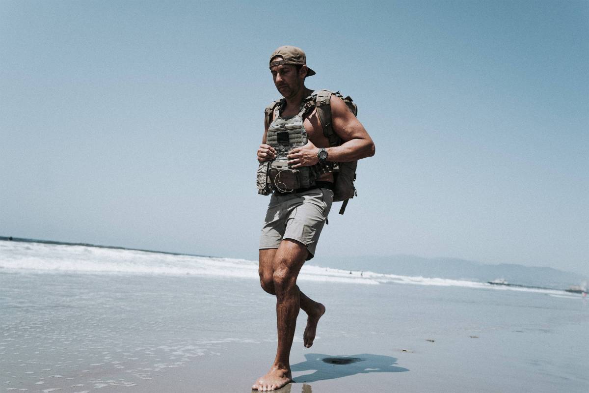 Kaj Larsen walks on the beach in Navy SEAL equipment.