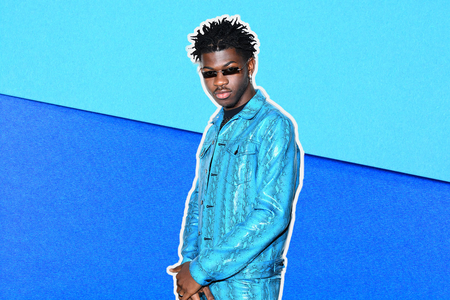 a photo of lil nas x wearing sunglasses against a two-toned blue background