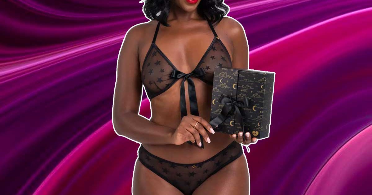 A woman in lingerie holding Lovehoney's lingerie advent calendar