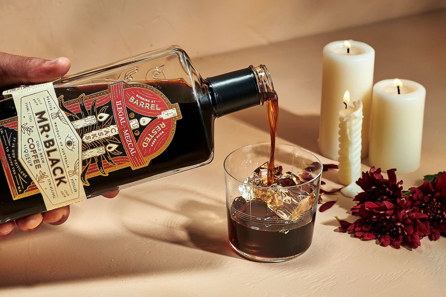 a product shot of the Mr Black Coffee Liqueur pouring into a glass on a tan background