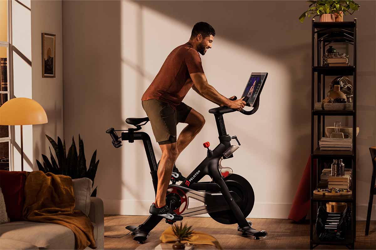 A man at home on a Peloton bike. The fitness brand has started selling some of its products on Amazon, marking a business shift.