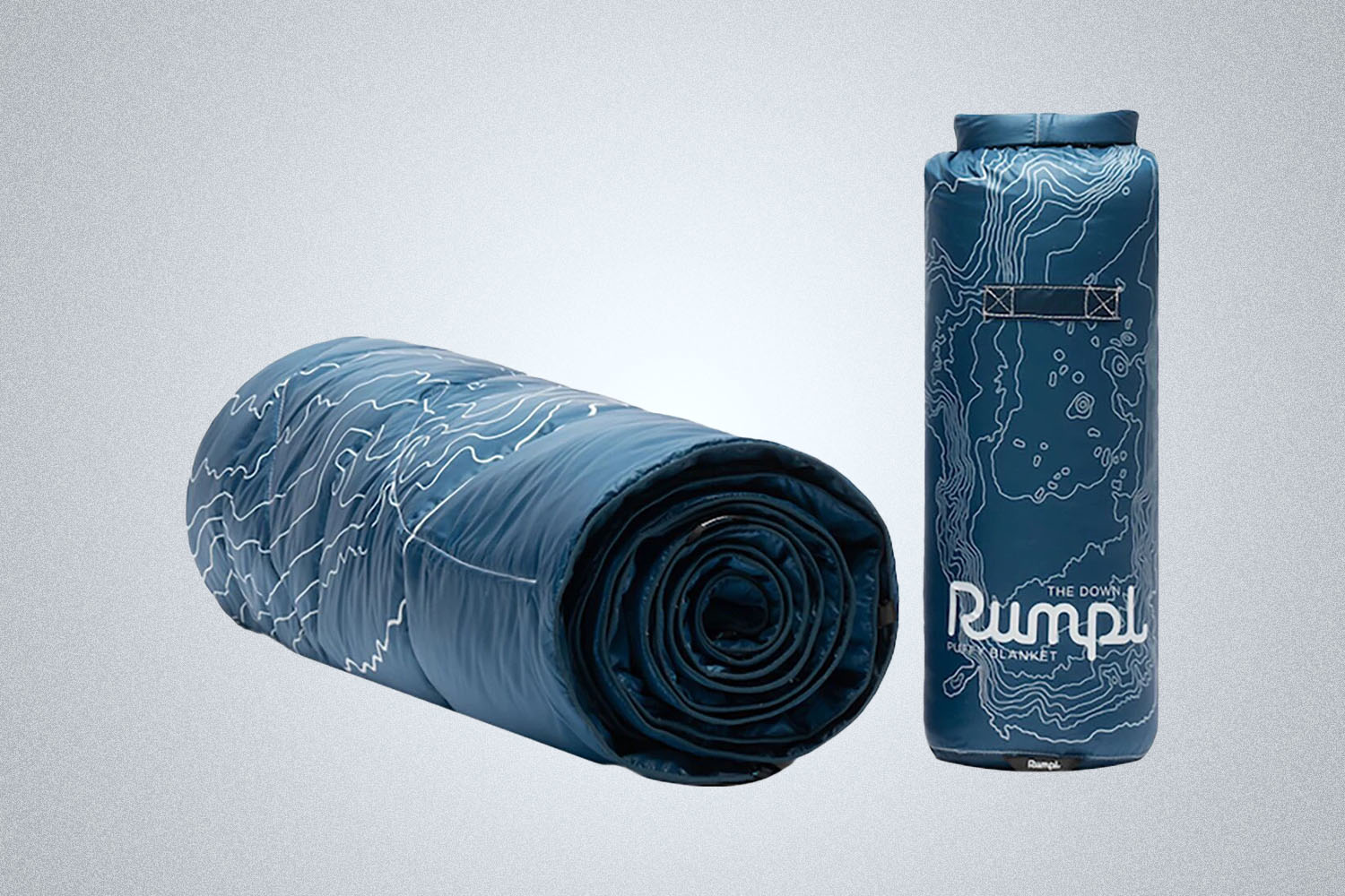 a blue RUMPL blanket rolled on a grey background