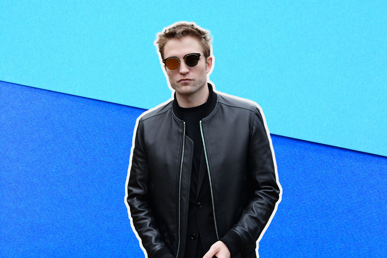 a photo of robert pattenson wearing sunglasses agaisnt a two-toned blue background