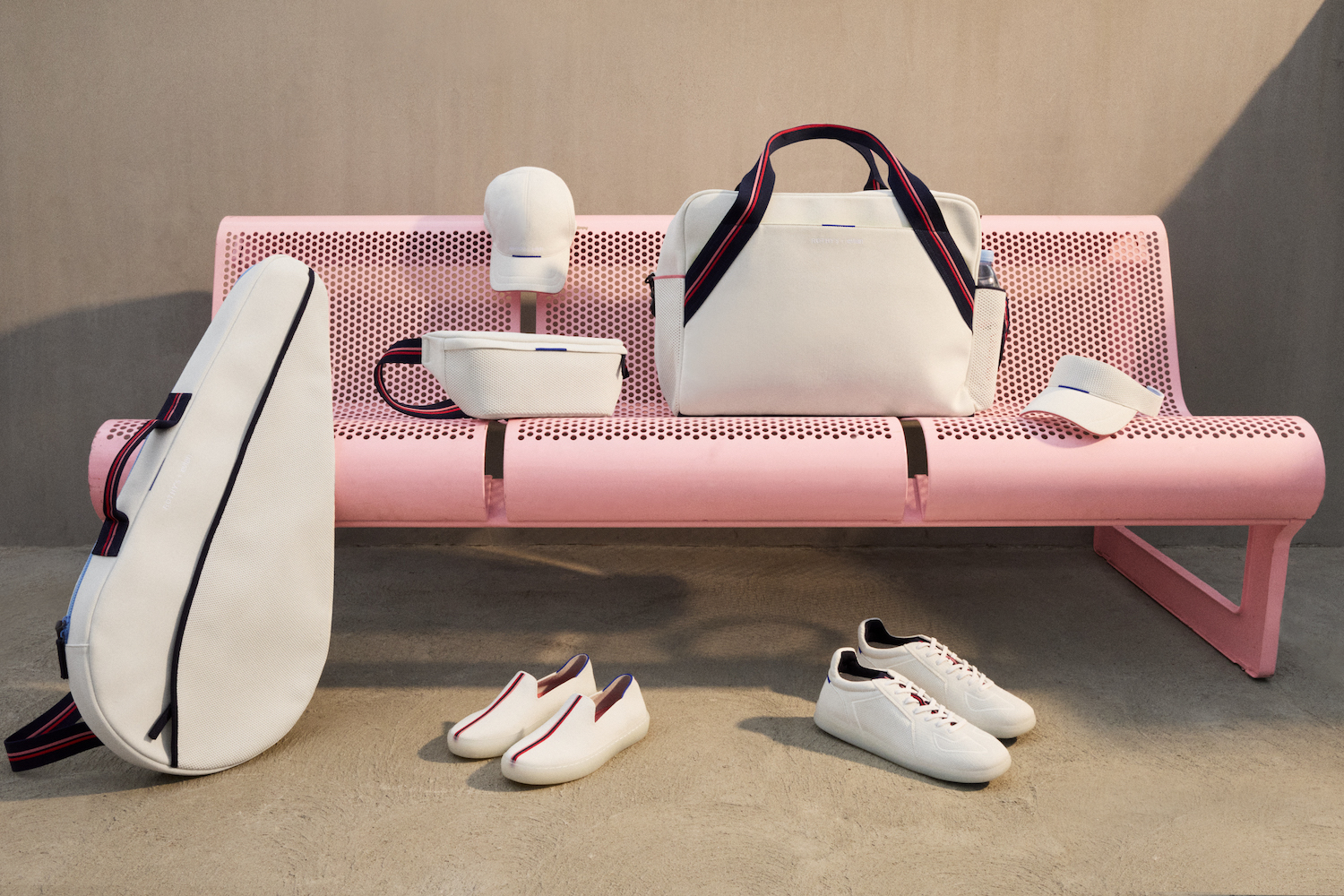 a collage of items from the Rothy's x evian collection on a pinl bench against concrete and pink background