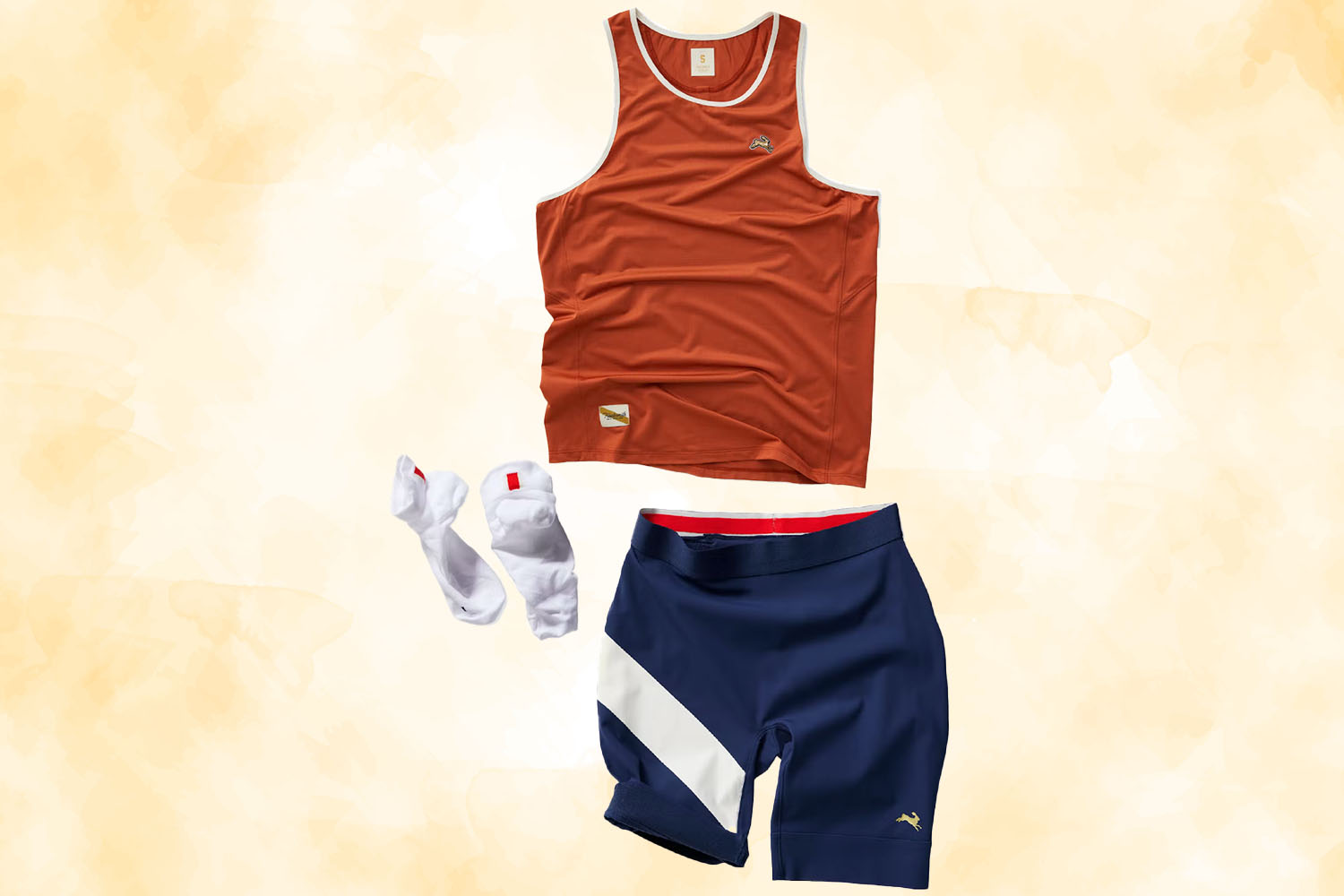 a Speed Racer kit with tank, short tights and socks from Tracksmith on a gold textured background