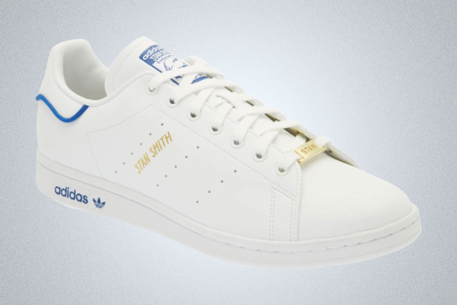 an all white Adidas Stan Smith sneaker on a grey background