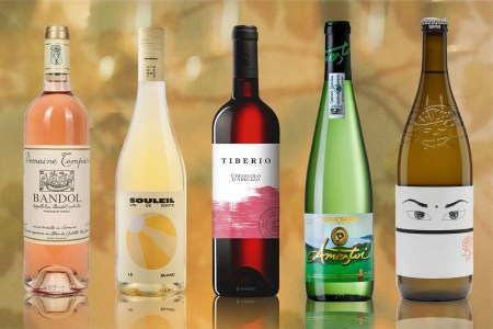 Bottles of white, rose and orange wine recommended by wine writer and sommelier Kate Dingwall on gold backdrop