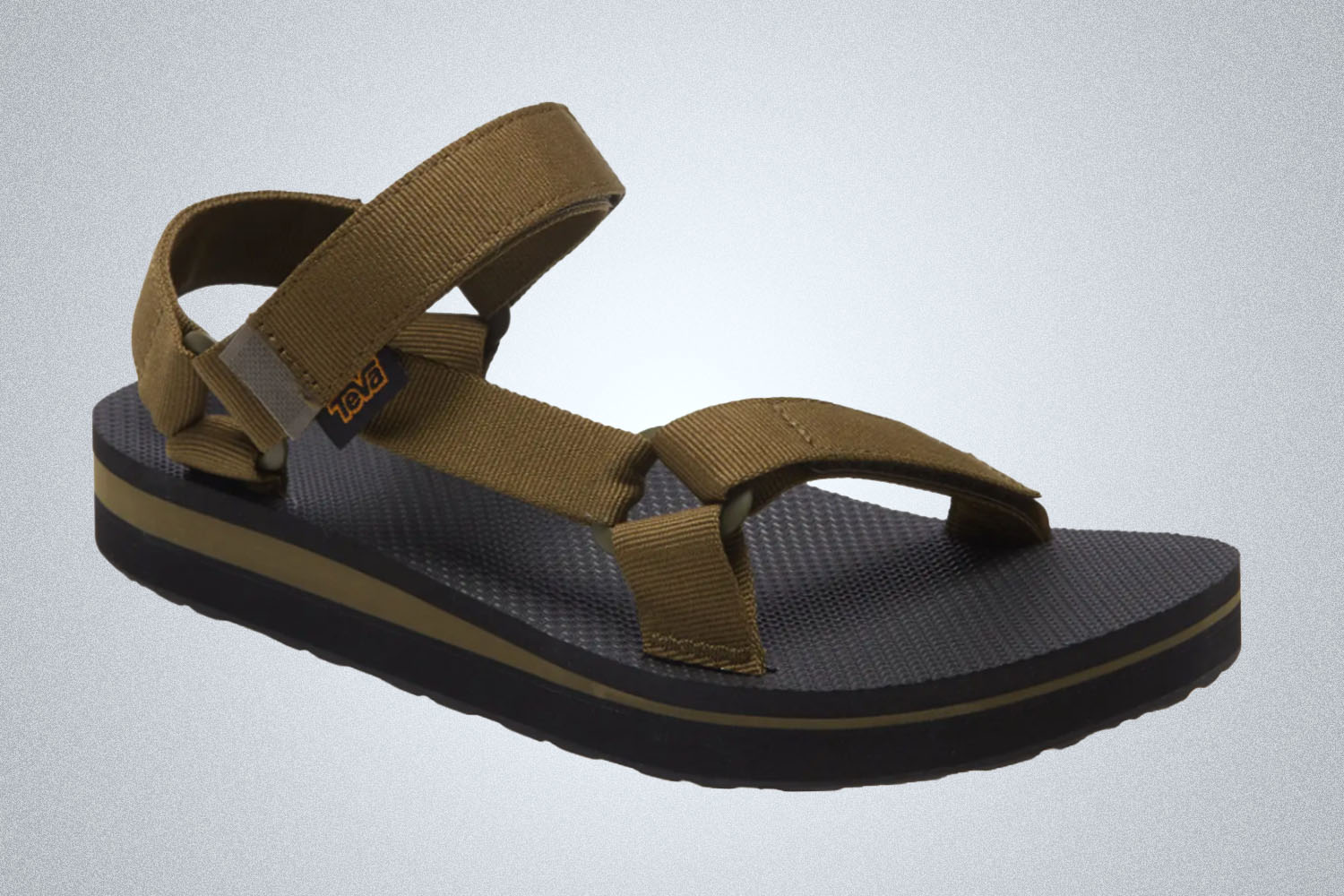 a black and green Teva sandal on a grey background