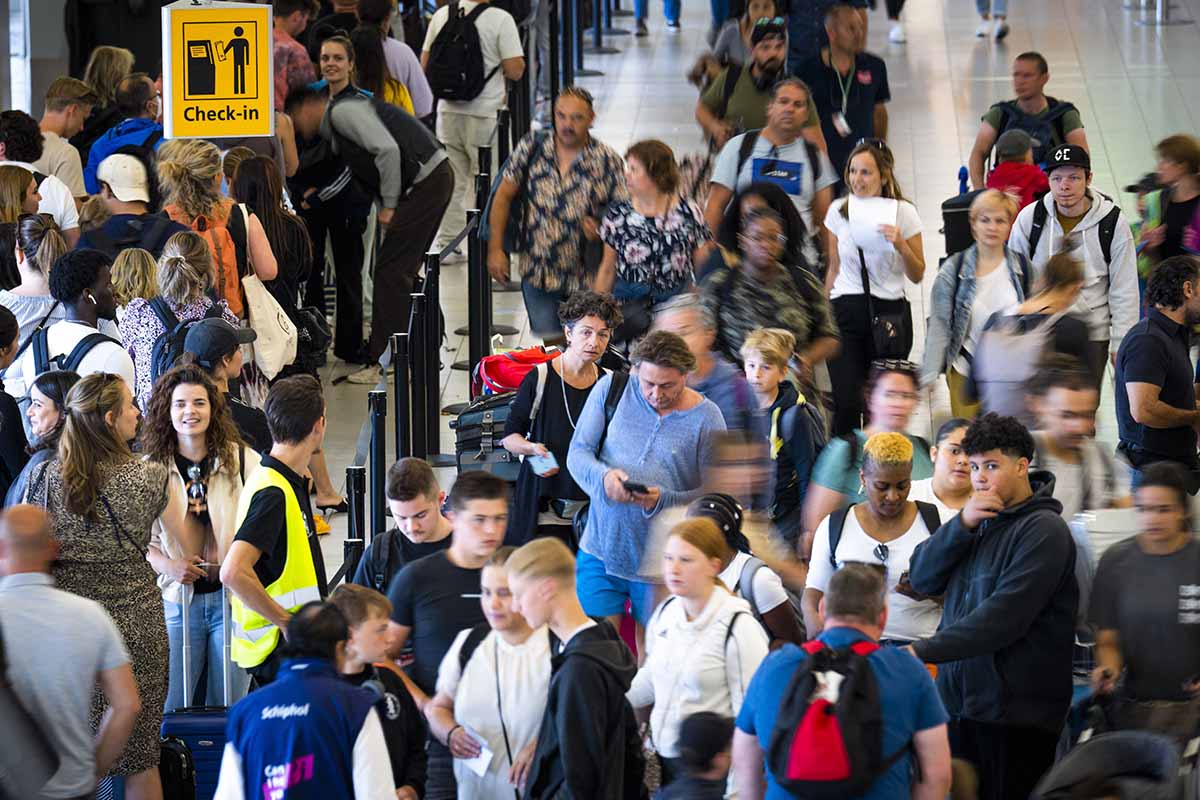 Passengers queue to check-in for flights at the Schiphol Airport on 29 July 2022. - Schiphol has been struggling with a shortage of security guards and baggage handlers for some time, and in combination with the increased flow of holidaymakers, this shortage has led to large crowds.