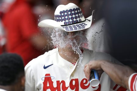 Mickey Moniak is congratulated for a home run with a cowboy hat and cup of water to the face in the ninth inning.