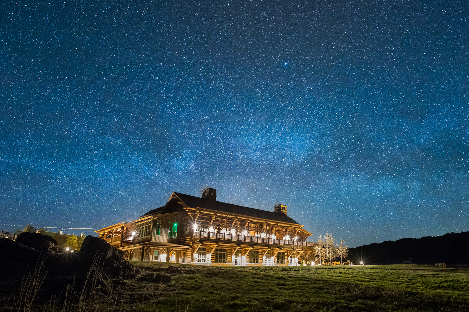 Brush Creek Ranch, one of the best luxury ranch resorts in the U.S., at night with a long exposure highlighting the stars in the sky